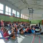 Uczniowie siedzą w sali gimnastycznej.jpg