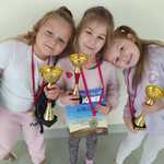 Trzy dziewczynki z medalami i pucharami.jpg