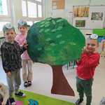 Dzieci trzymają ogromne drzewo wykonane z kartonu.jpg.jpg