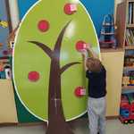 Dziecko przykleja karteczki do dużego drzewa z kartonu.jpg.jpg