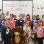 Zdjęcie grupowe dzieci z pluszowymi misiami.